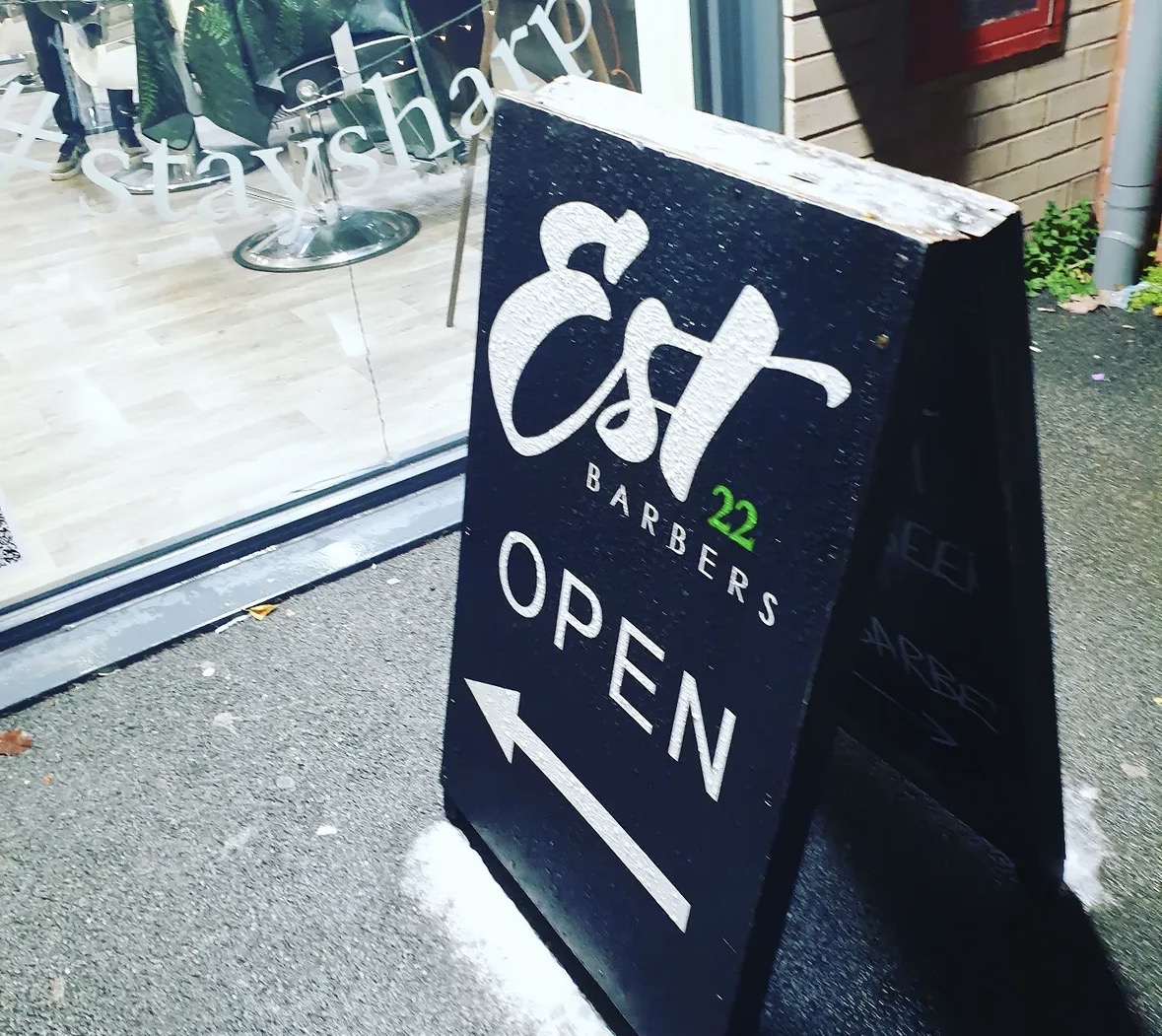 The EST22 Barbers open sign outside the shop